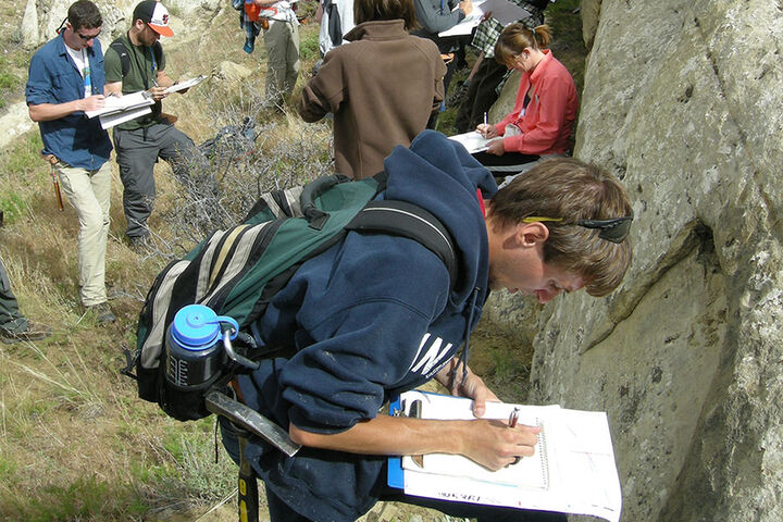A group of students conducts geologic field studies.